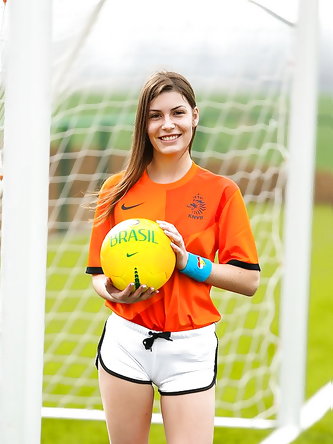 Lilly P is undressing her soccer uniform while on the field with a ball