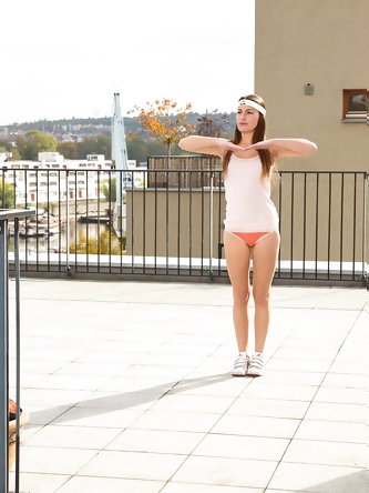 Barely legal girl gets naked on a rooftop patio in a headband and sneakers
