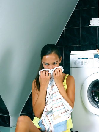Young looking brunette shows her budding tits and tight slit on laundry day